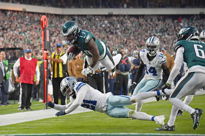 Philadelphia Eagles running back Kenneth Gainwell (14) dives over Dallas Cowboys cornerback Stephon Gilmore (21) on a 12-yard touchdown run during the first quarter at Lincoln Financial Field.